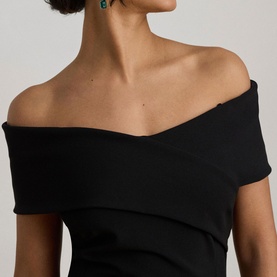 Model wearing Lauren black off-shoulder dress, styled with green drop earrings, close-up neckline detail shot.