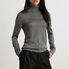 Model wearing Lauren black and silver metallic fine-knit roll-neck jumper, styled with dark wide-leg trousers