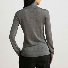 Model wearing Lauren black/silver turtleneck knit jumper, rear view, styled with dark trousers