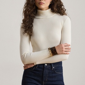 Model wearing Lauren Mascarpone Cream ribbed turtleneck knit top, styled with dark indigo jeans and gold chain bracelet
