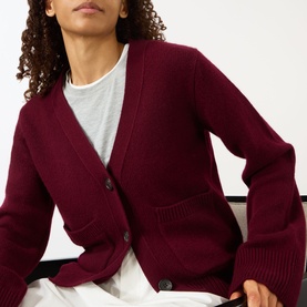 Model wearing Lisa Yang Deep Plum cashmere cardigan with V-neck, button front and ribbed cuffs, styled with a white T-shirt.