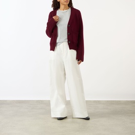 Model wearing Lisa Yang Deep Plum cashmere cardigan, styled with a grey top and wide-leg cream trousers.