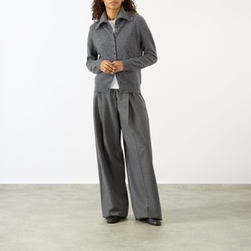 Model wearing Lisa Yang The Denie Knit Cardigan in Graphite, styled with wide-leg grey trousers and black shoes.