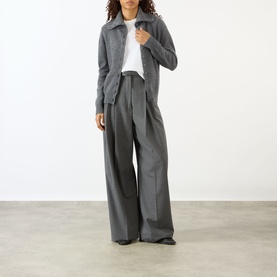 Model wearing Lisa Yang The Denie Knit Cardigan in Graphite, cashmere with flat collar and button fastening, styled with wide-leg grey trousers