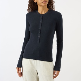 Model wearing Lisa Yang Airi Knitted Cashmere Polo Shirt in navy, ribbed finish, half-button placket, long sleeves, styled with grey trousers