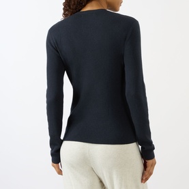 Model wearing Lisa Yang Airi Knitted Cashmere Polo Shirt in navy, back view, ribbed finish, long sleeves, styled with grey trousers