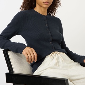 Model wearing Lisa Yang Airi Knitted Cashmere Polo Shirt in navy, ribbed finish with half-button placket, styled with cream drawstring trousers.