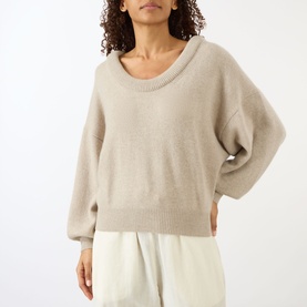 Model wearing Lisa Yang The Doria Cashmere Sweater in sand, with scoop neckline and relaxed fit, styled with cream wide-leg trousers.