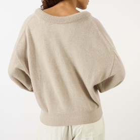 Model wearing Lisa Yang The Doria Cashmere Sweater in Sand, showing back view with scoop neck, batwing sleeves and ribbed trims