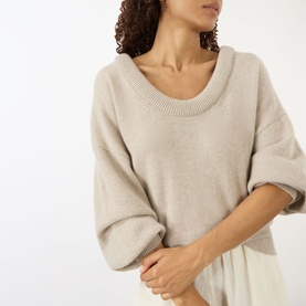 Model wearing Lisa Yang The Doria Cashmere Sweater in sand, featuring scoop neckline, balloon sleeves and ribbed trims