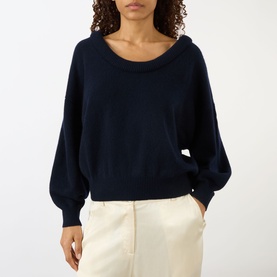 Model wearing Lisa Yang The Doria Cashmere Sweater in navy with scoop neckline, balloon long sleeves and ribbed trims, styled with cream trousers
