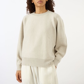 Model wearing Lisa Yang The Hally Cashmere Sweater in Oyster, crew neck with ribbed trims, styled with wide-leg cream trousers.