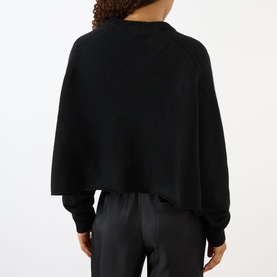 Model wearing Lisa Yang The Karine Sweater in black cashmere, rear view, showing dropped shoulders and ribbed trims, styled with black leather