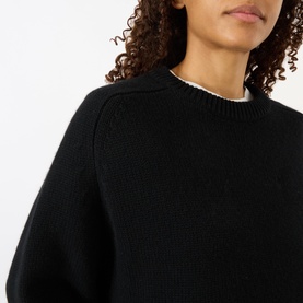 Model wearing Lisa Yang The Karine Sweater in black cashmere, featuring crew neckline with ribbed trim and dropped shoulders.