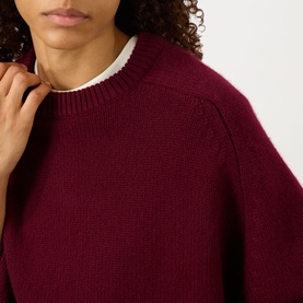 Model wearing Lisa Yang The Karine Sweater in Deep Plum, crew neck cashmere knit with dropped shoulders and ribbed trims, styled with white collared