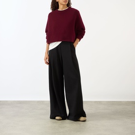 Model wearing Lisa Yang The Karine Sweater in Deep Plum, cropped cashmere knit with crew neck and dropped shoulders, styled with wide-leg black