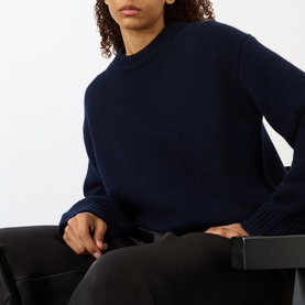 Model wearing Lisa Yang Noor Cashmere Sweater in navy with crew neck and ribbed trims, styled with black trousers