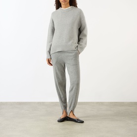 Model wearing Lisa Yang The Noor Knit Sweater in Dove Grey, crew neck cashmere knit, styled with matching grey knit trousers and black flats.
