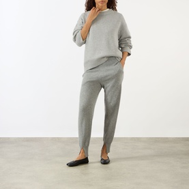 Model wearing Lisa Yang The Noor Knit Sweater in Dove Grey, styled with matching grey knit trousers and black ballet flats