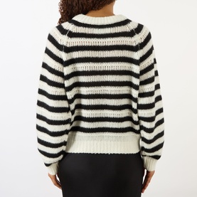 Model wearing Lisa Yang cashmere-silk knit in cream and black stripes, back view, styled with black trousers.