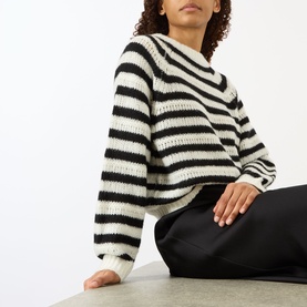 Model wearing Lisa Yang cream and black stripe cashmere-silk knit jumper with relaxed fit, styled with black trousers
