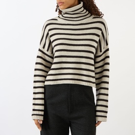Model wearing Lisa Yang Zerlina Striped Turtleneck Sweater in Oyster and Dark Oak stripes, with ribbed trims and long sleeves, styled with black