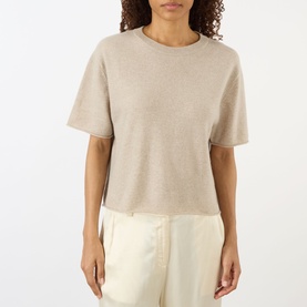 Model wearing Lisa Yang sand cashmere T-shirt with crew neck and short sleeves, styled with cream wide-leg trousers.