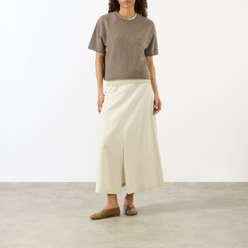 Model wearing Lisa Yang Truffle cashmere T-shirt, styled with a cream midi skirt and taupe flat mules.
