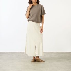 Model wearing Lisa Yang Truffle cashmere T-shirt, styled with cream midi skirt and tan flat shoes.
