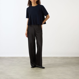 Model wearing Lisa Yang Liru Cashmere T-Shirt in navy, round neck, short sleeves, styled with dark wide-leg trousers and black flats.