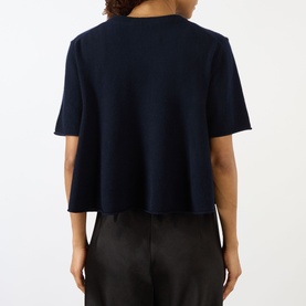 Model wearing Lisa Yang Liru Cashmere T-Shirt in navy, back view, round neck, short sleeves, straight hem, styled with black trousers.