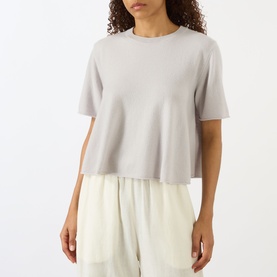 Model wearing Lisa Yang Liru Cashmere T-Shirt in Seashell, round neck, short sleeves, styled with cream wide-leg trousers.