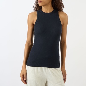 Model wearing Lisa Yang Amya Rib Tank Top in navy, sleeveless with round neck and ribbed finish, styled with light grey trousers