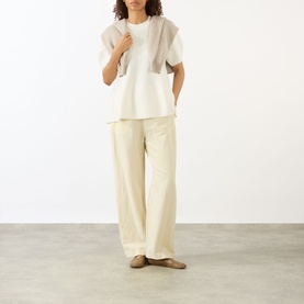 Model wearing Lisa Yang The Mella Peplum Top in Cream, crew neck, short sleeves, peplum hem, styled with wide-leg cream trousers and flat shoes.