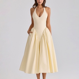Model wearing pale yellow halterneck midi dress with deep V-neckline, fitted bodice, and full pleated skirt with side pockets