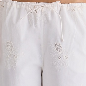 House of CB white cotton trousers with floral broderie anglaise embroidery and drawstring waist, close-up detail shot