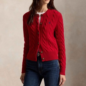 Model wearing Polo Ralph Lauren red cable-knit cardigan with navy logo, styled with white shirt and dark denim jeans.