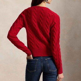 Model wearing Polo Ralph Lauren red cable-knit cardigan, back view, styled with blue denim jeans.