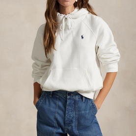 Model wearing Polo Ralph Lauren white hoodie with drawstring hood and navy logo, styled with blue wide-leg jeans.