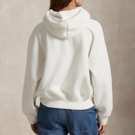 Model wearing Polo Ralph Lauren white hoodie, back view, styled with blue denim jeans