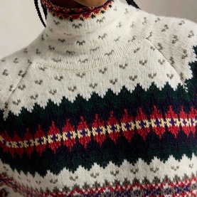 Model wearing Polo Ralph Lauren cream multi Fair Isle turtleneck knit, close-up detail showing geometric and snowflake pattern in red, navy and grey