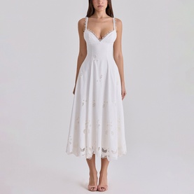 Model wearing House of CB white midi dress with spaghetti straps, sweetheart neckline, and floral broderie anglaise skirt, styled with nude heeled