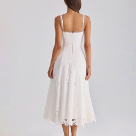 Model wearing House of CB white midi dress with spaghetti straps, floral appliqu&eacute; detail, and scalloped lace hem, back view