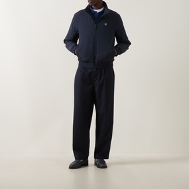 Model wearing Calvin Klein Jeans Dark Sapphire nylon casual jacket with matching navy trousers and dark loafers.