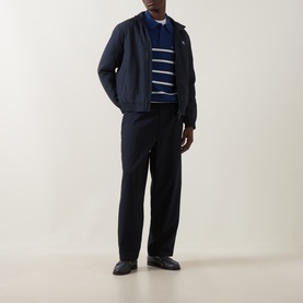 Model wearing Calvin Klein Jeans Dark Sapphire nylon casual jacket, styled with navy striped jumper and dark tailored trousers.