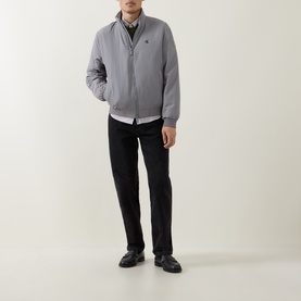 Model wearing Calvin Klein Jeans Harrington Logo Weatherproof Jacket in Convoy grey, styled with black trousers and loafers