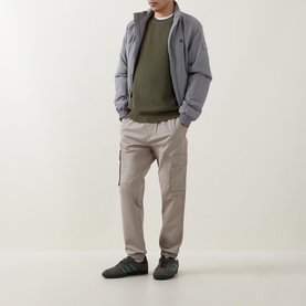 Model wearing Calvin Klein Jeans Comfort Skinny Leg Cargo Trousers in Vintage Khaki with grey puffer jacket and khaki sweatshirt.