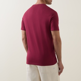 Model wearing Calvin Klein Jeans Rhododendron cotton crew neck T-shirt, shown from the back, styled with cream trousers.