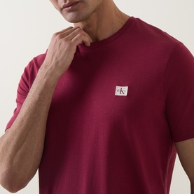 Model wearing Calvin Klein Jeans Rhododendron crew neck T-shirt in cotton, featuring small logo badge on chest.