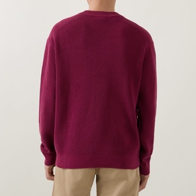 Model wearing Calvin Klein Jeans Badge Logo Waffle-Knit Sweatshirt in Rhododendron, crew neck, back view, styled with beige trousers.